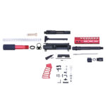 Assorted AR-15 red and black gun parts kit displayed on a flat surface.