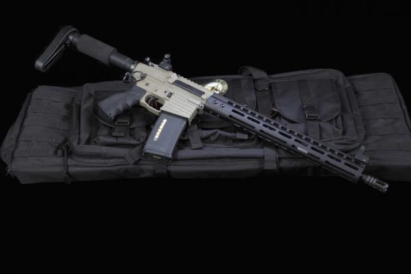 Modern AR-style rifle with tan finish and black M-LOK handguard on a dark background.