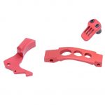 Red anodized AR-15 parts kit: trigger guard, angular component, skull-design button.