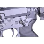 Close-up of AR-15 lower receiver showing safety selector switch and precision-machined metalwork.