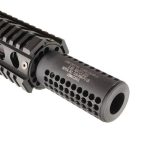 Close-up of AR-15 tactical muzzle device with perforations for gas dispersion, attached to rail.