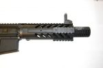 Close-up of a tactical firearm barrel with muzzle brake and Picatinny rail system.