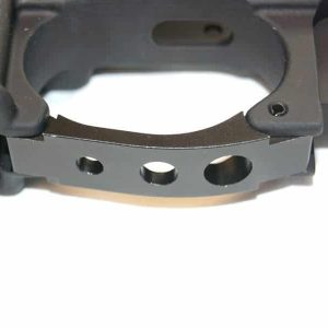 Close-up of AR-15 trigger guard with machined holes, emphasizing craftsmanship and design.