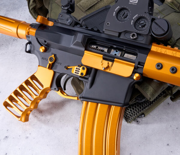 Custom orange and black rifle with skeleton grip and advanced optics.