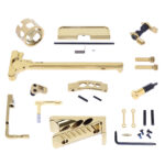 High-end gold pistol components laid out for custom firearm assembly.