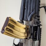 Gold magazine machine gun with ergonomic handle and robust structure.