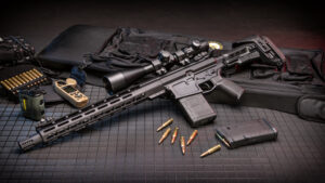 AR-style rifle with tactical scope and accessories on organized display.