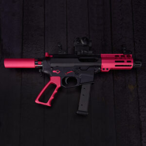 Compact black and pink 9mm rose pistol on wooden background.