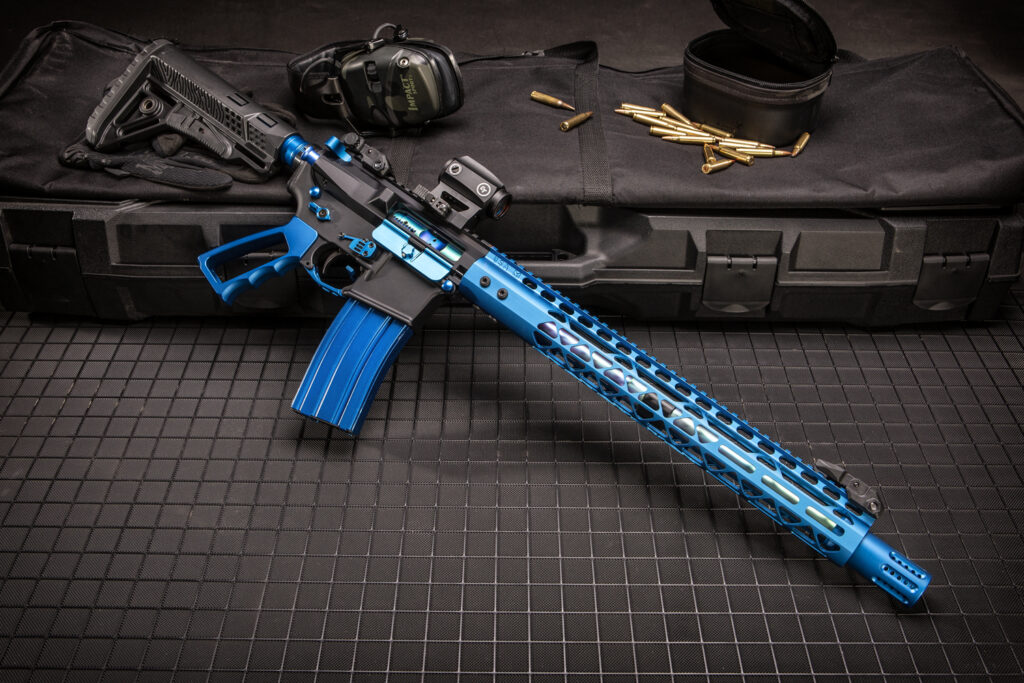 Custom blue and black rifle with accessories on a rugged case for precision shooting.