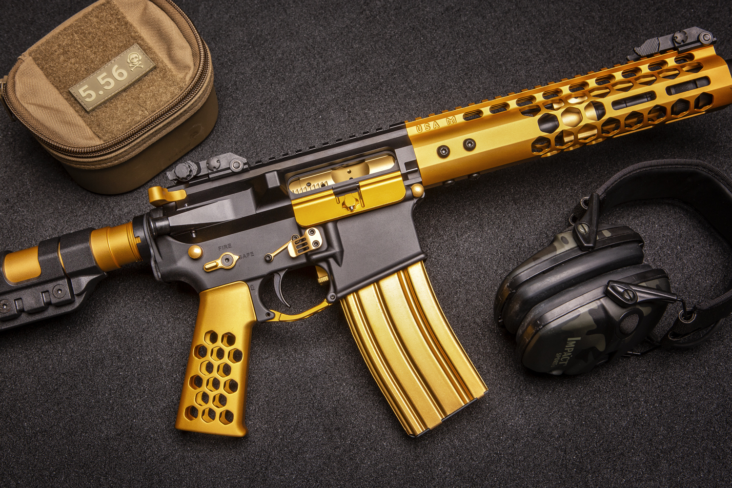 Custom gold firearm with intricate design, ergonomic grip, and essential accessories on dark background.