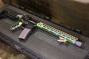 Colorful neon-striped custom rifle displayed on a secure black case.