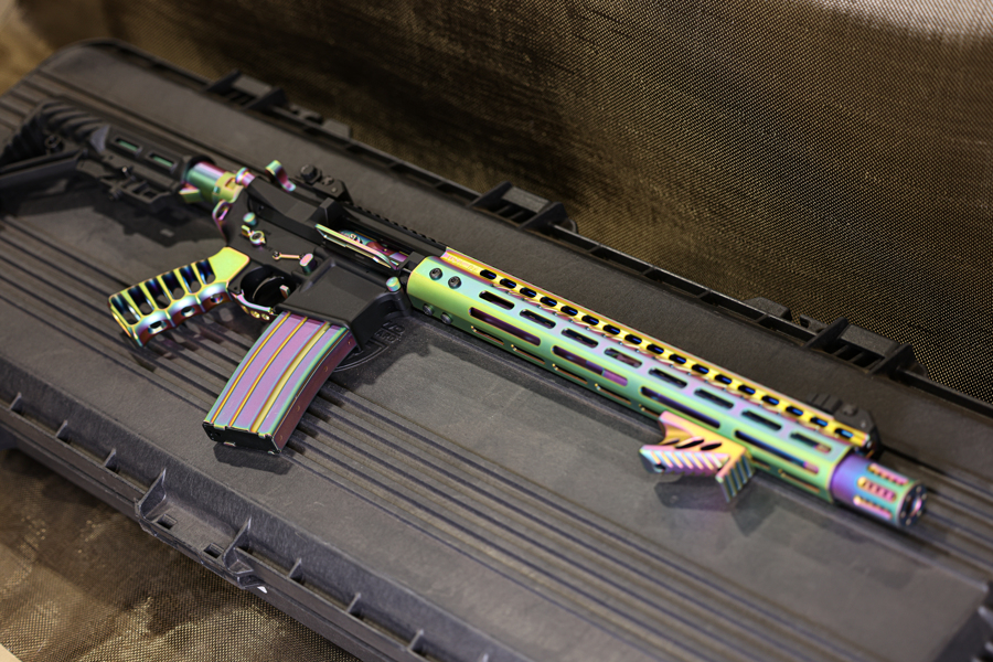 Colorful neon-striped custom rifle displayed on a secure black case.