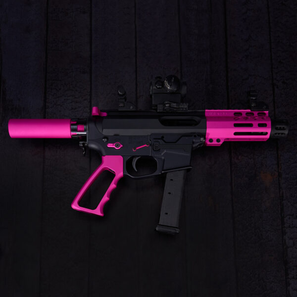 Pink-accented 9mm submachine gun on wooden background.