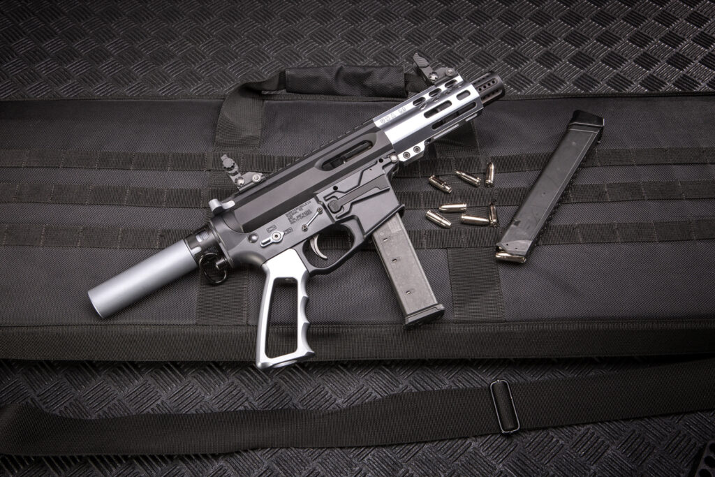 Modern tactical pistol-carbine on padded case with magazine and ammunition.