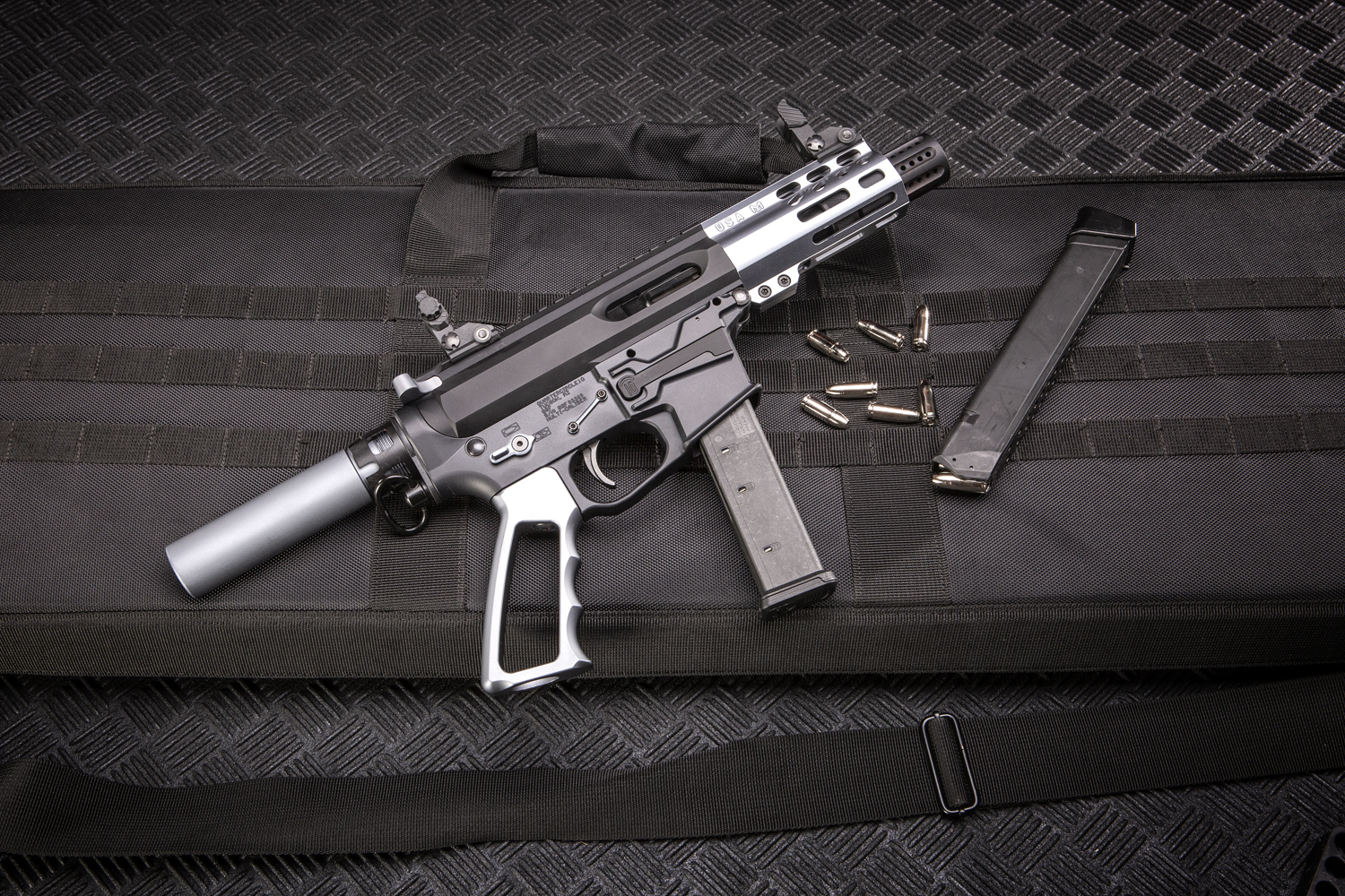 Modern tactical pistol-carbine on padded case with magazine and ammunition.