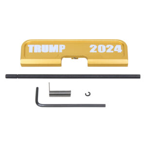 Gold AR-15 charging handle with TRUMP 2024 engraving on white background.