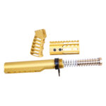 Gold-anodized AR-15 compensator kit with precision-machined parts on white background.